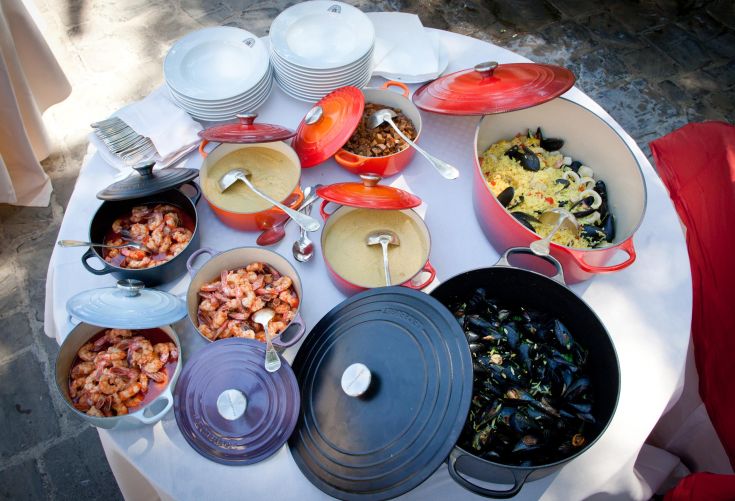Une table ronde dressée avec une variété de plats typiques, y compris des risottos et d'autres spécialités locales.
