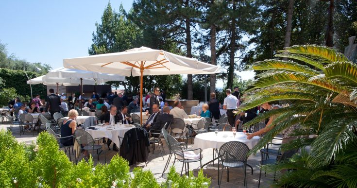 Restaurant en plein air entouré d'arbres, parfait pour des repas dans la nature le jour et le soir.