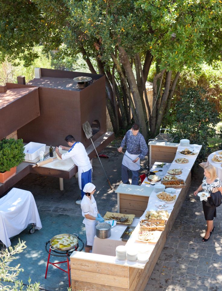 Un espace de cuisine extérieure où le chef prépare des plats traditionnels pour les invités.