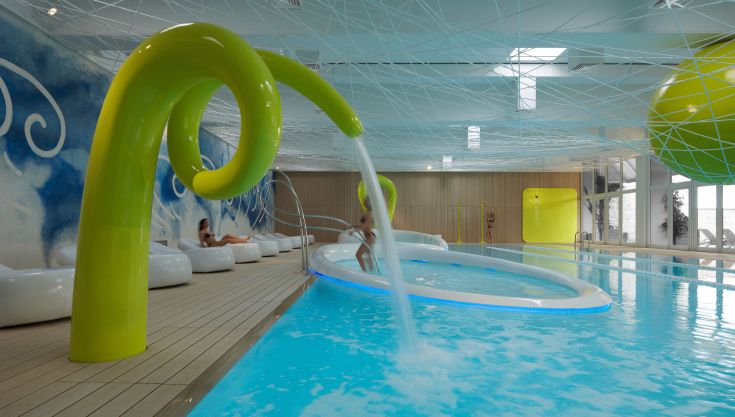 Une piscine intérieure immergée dans un environnement contemporain, idéale pour la détente et le bien-être.