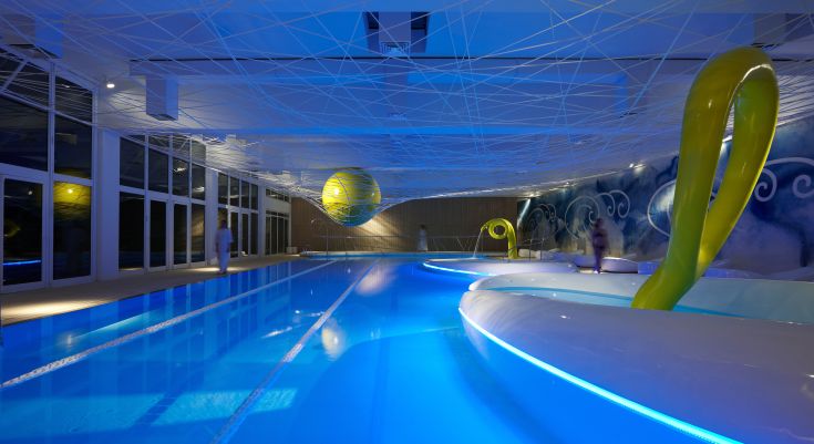 Une piscine au design simple avec un éclairage bleu et des détails modernes, parfaite pour la détente.