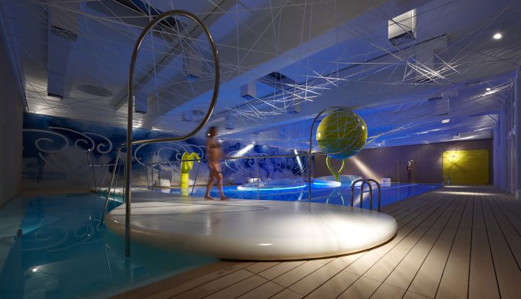Intérieur lumineux et simple d'un centre de bien-être avec piscine et mobilier élégant.