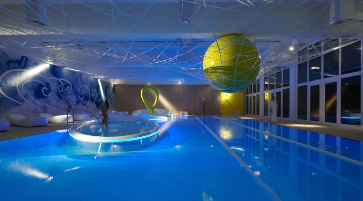Un centre de bien-être avec une piscine intérieure et un mobilier contemporain, idéal pour des moments de détente.