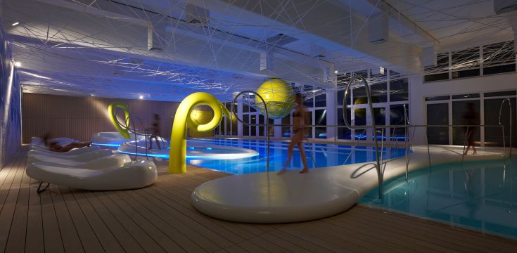 Une zone de détente contemporaine avec piscine, caractérisée par des lignes épurées et un éclairage doux qui crée une ambiance chaleureuse.