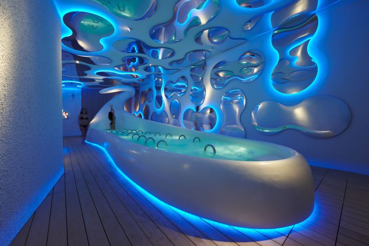 Une zone de bien-être au design simple, avec une baignoire et un éclairage bleu doux.