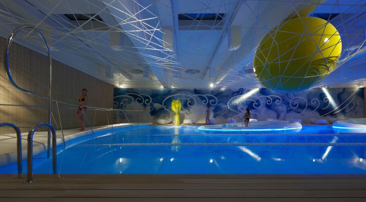 Piscine intérieure avec éclairage tamisé et détails décoratifs. Un espace dédié à la détente et au bien-être des clients.