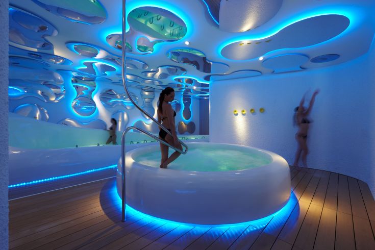 Un spa contemporain avec un éclairage bleu et un design unique, idéal pour des moments de détente.