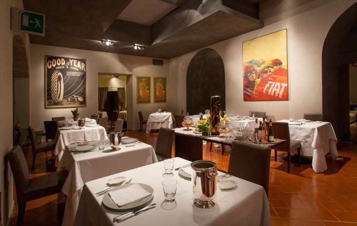 Intérieur d'un restaurant avec des tables dressées et des décorations murales.