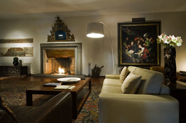 Salon avec une cheminée centrale, un mobilier simple et des plantes, idéal pour des moments de détente.