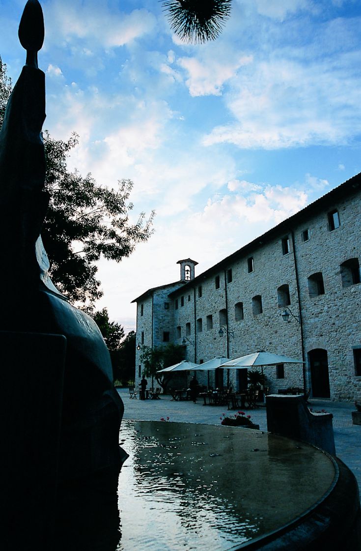 Scène du Park Hotel ai Cappuccini à Gubbio, un bâtiment historique entouré de verdure.