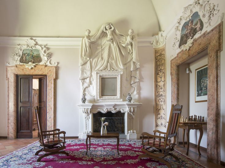 Ein klassisches Wohnzimmer mit Kamin und eleganten Möbeln, die eine historische Atmosphäre schaffen.