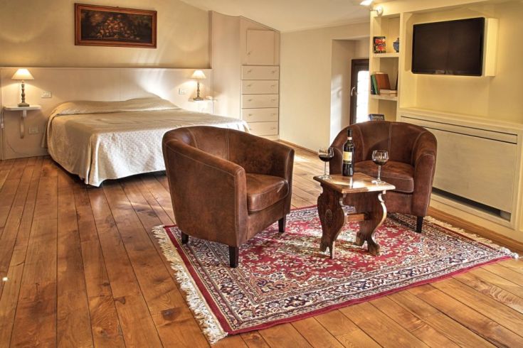 Einfache Zimmer mit historischen Elementen und ordentlich aufgestellten Betten für einen entspannten Aufenthalt.