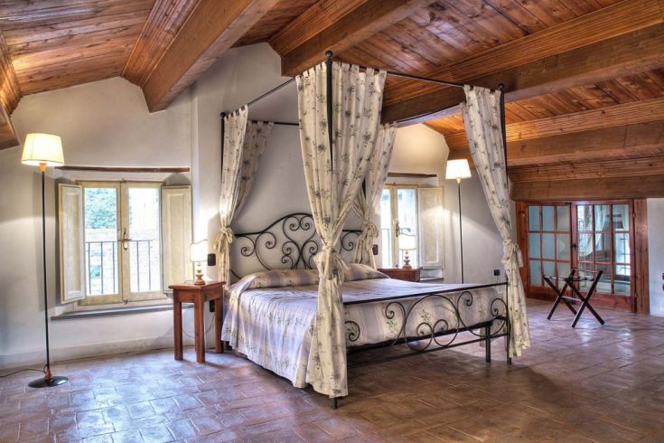 Gemütliches Zimmer mit Holzdeckenbalken und Himmelbetten. Historische und komfortable Atmosphäre.