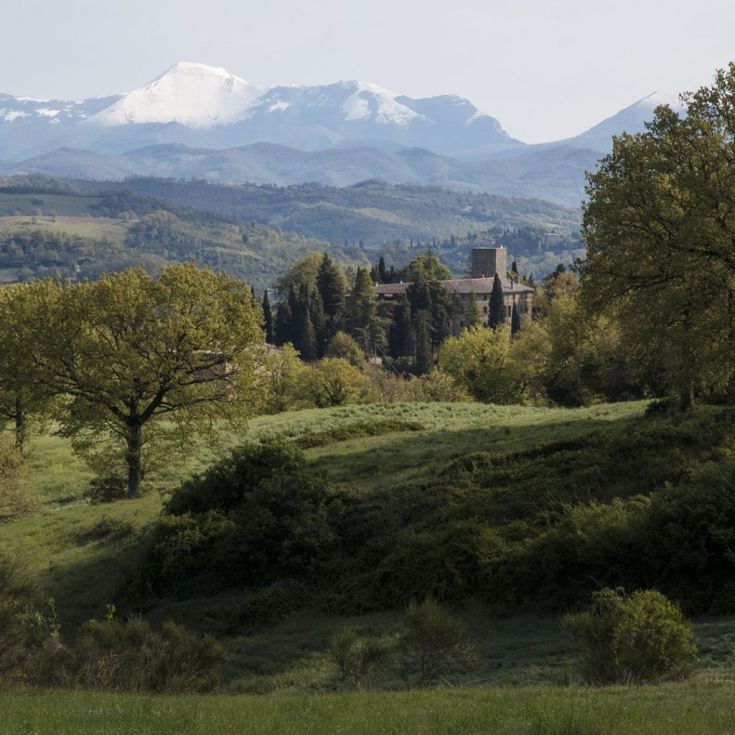 Eine Burg in Umbrien, umgeben von Hügeln und Bergen, mit panoramischem Blick auf die Natur.