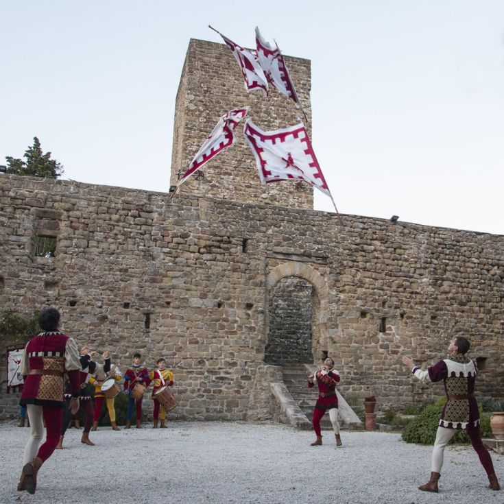 Traditionelle Aufführung mit Fahnen am Palazzo di Petroia, in einem historischen und festlichen Rahmen.
