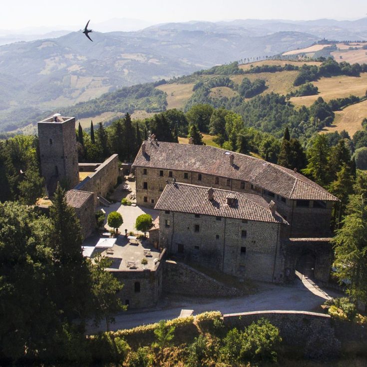 Burg Petroia, eine historische Struktur mit verschiedenen Gästezimmern, eingebettet in eine umbrische Landschaft.