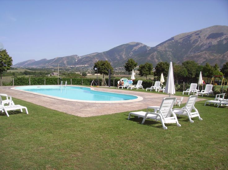 Momenti di relax a bordo piscina immersi nella natura, circondati da una scena montana.