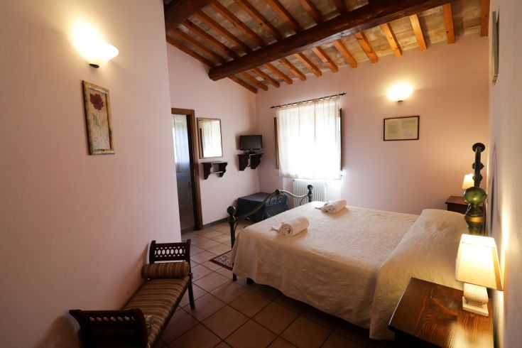 Einfaches Zimmer mit Betten, Fernseher und funktionalem Mobiliar, geeignet für einen komfortablen Aufenthalt.