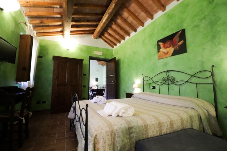 Gemütlicher Raum mit grünen Wänden und Holzstrahlen, ideal für Entspannungsmomente.