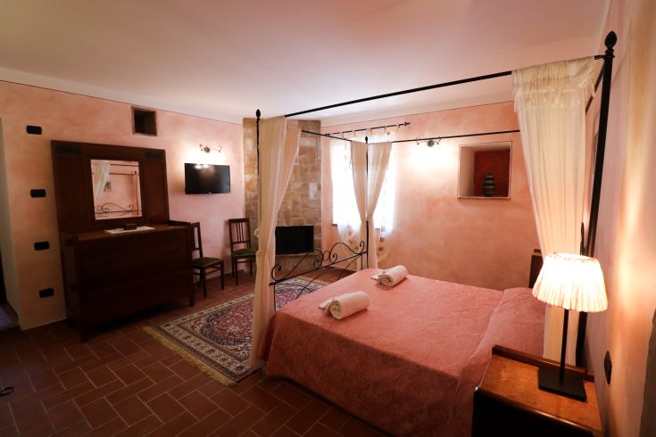 Gemütliches Zimmer in einem Agriturismo mit einem Doppelbett, einfacher Einrichtung und warmer Beleuchtung.