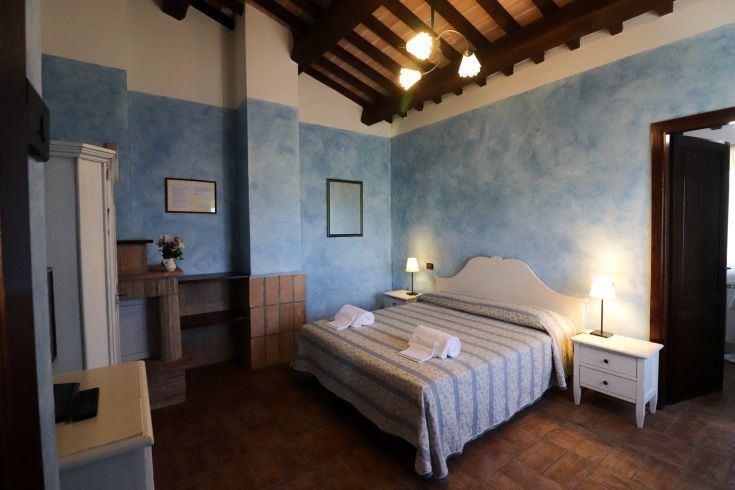 Einfache Zimmer im Agriturismo Villa Dama, geprägt von blauen Farbtönen und schlichter Einrichtung.
