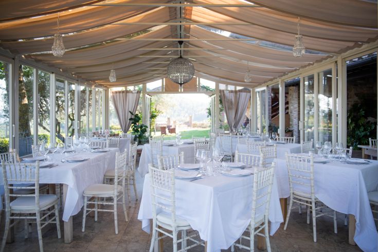 Geräumiger Essraum in einem Bauernhaus, mit ordentlich angerichteten Tischen zur Begrüßung der Gäste bei einer Veranstaltung.