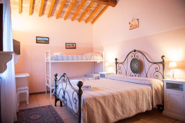 Einfache Zimmer mit Etagenbetten und Doppelbett, rustikale Einrichtung und ruhige Atmosphäre.