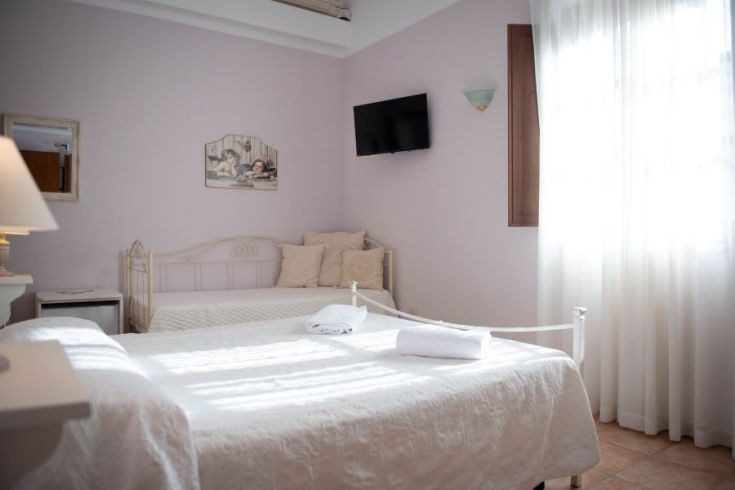 Helle und gemütliche Zimmer in einem Agriturismo, mit gut angeordneten Betten und funktionalem Mobiliar.