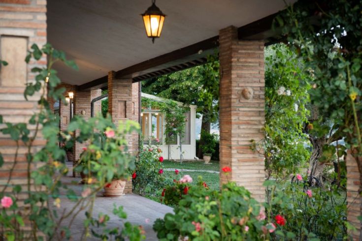 Panorama eines Agriturismo mit einem gut gepflegten Garten und einer typischen Landhausstruktur.