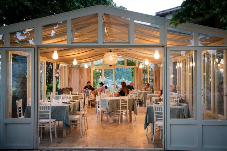 Ein Speisezimmer mit gut angeordneten Tischen, umgeben von einer natürlichen und ruhigen Umgebung.