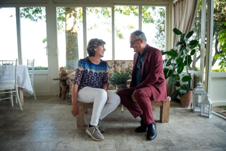 Zwei Personen, die in einer hellen und gemütlichen Umgebung plaudern und lächeln.