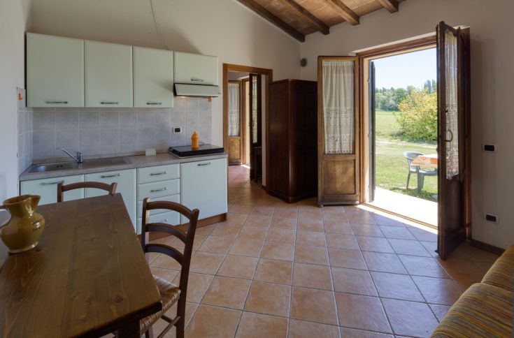 Una cucina accogliente, arredata in modo semplice, con affaccio sulla natura, perfetta per socializzare.