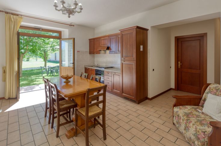 Spaziosa cucina con accesso diretto al giardino, perfetta per momenti in famiglia. Ambienti luminosi e pratici.