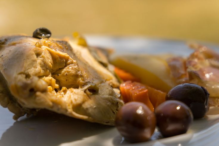 Piatto di carne accompagnato da contorni freschi, servito su un piatto semplice.