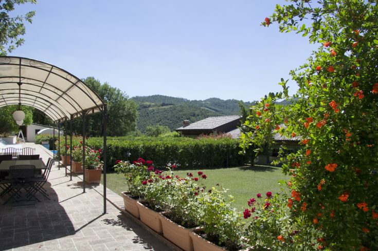 Un giardino luminoso con fiori variopinti e uno splendido panorama sulle colline, ideale per momenti di tranquillità.