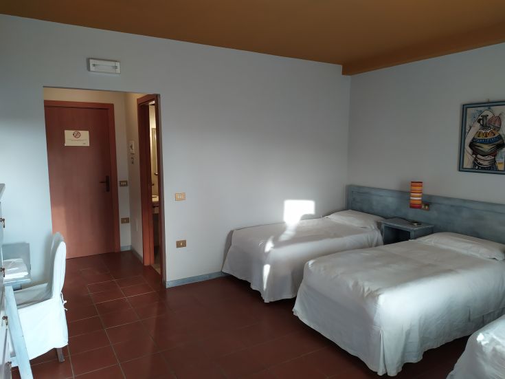 Camera arredate con letti singoli e decorazioni sobrie, in un ambiente accogliente.