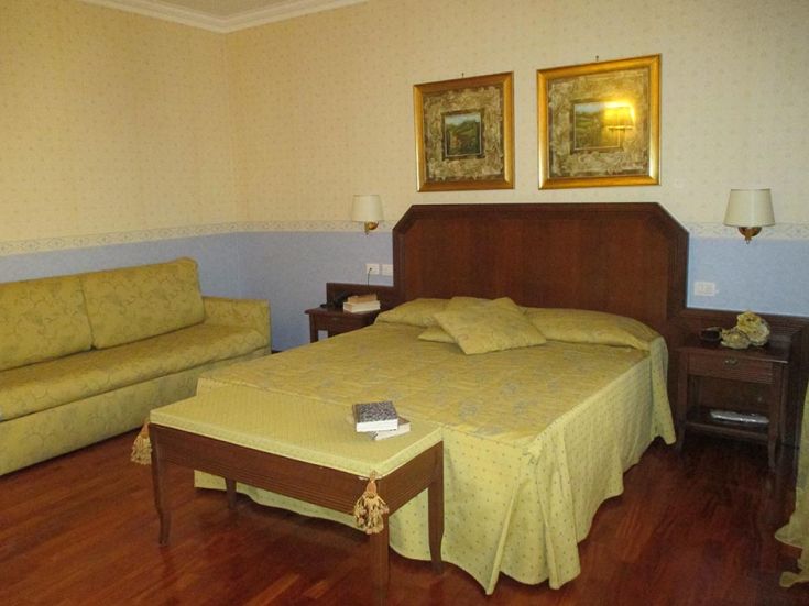 Einfaches Zimmer mit Holzmöbeln und weichen Stoffen, ideal für einen entspannenden Aufenthalt.