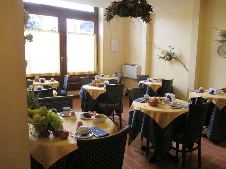 Geräumiger Frühstücksraum mit gut angeordneten Tischen und frischem Obst in einer hellen Umgebung.