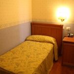 Gemütliches Hotelzimmer mit Holzfußboden und einfacher Einrichtung, perfekt für einen entspannten Aufenthalt.