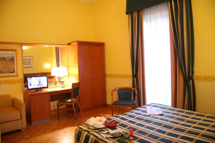 Camera confortevole in un hotel, con un arredamento semplice e colori caldi.