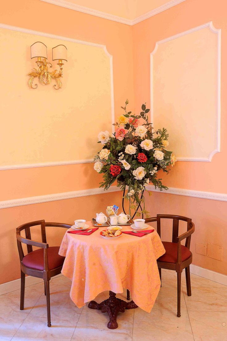 Un angolo curato con un tavolo apparecchiato, fiori freschi e un'atmosfera piacevole.