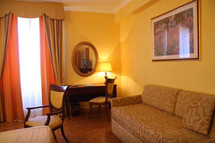 Soggiorno dalle tonalità calde, arredato in modo classico, perfetto per momenti di relax.