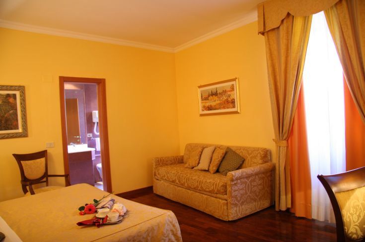 Camera confortevole con arredo semplice e finestra che affaccia su un paesaggio umbro.