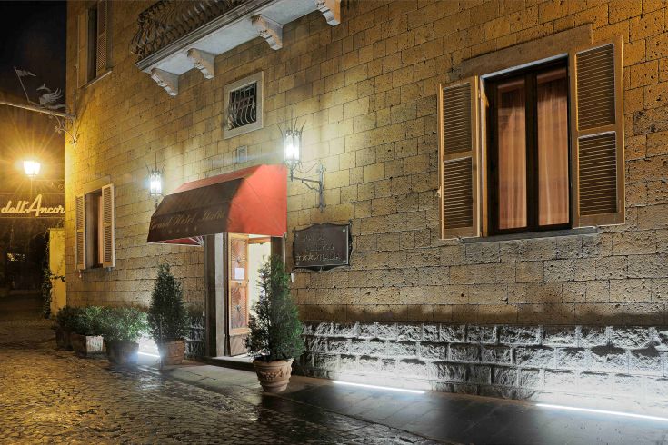 L'ingresso del Grand Hotel Italia, elegante struttura in un palazzo storico a Orvieto, situato in una zona urbana tranquilla.