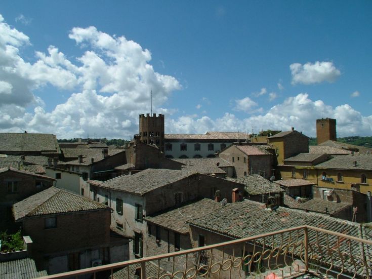 Scena di tetti e torri che si elevano in un tipico borgo storico dell'Umbria.