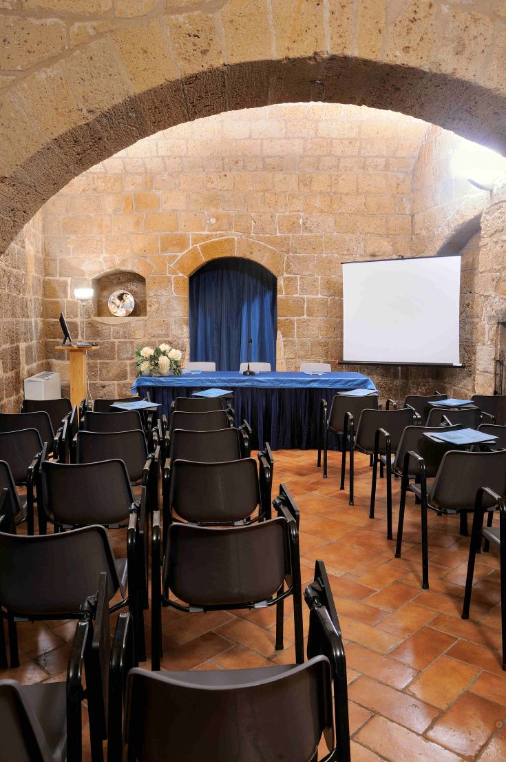 Ambiente accogliente di una sala conferenze con arredi classici e sedute ben organizzate.