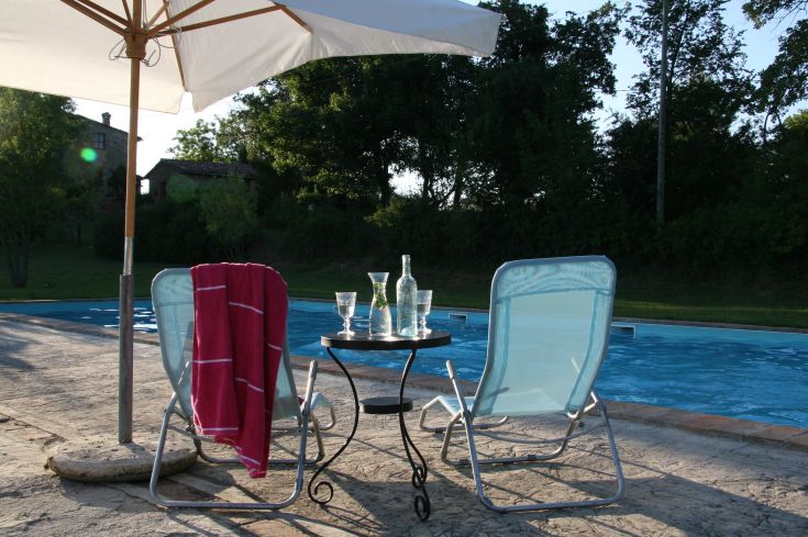 Un angolo di tranquillità con lettini a bordo piscina, perfetto per godere del sole e del relax.