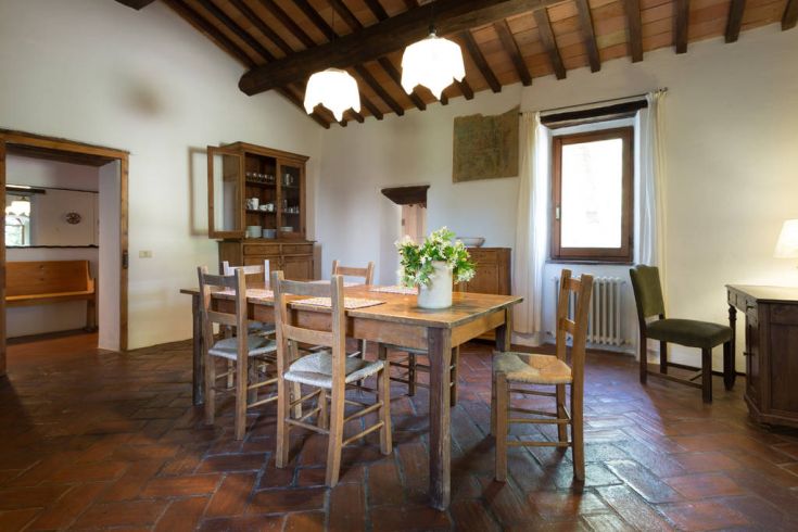 Una sala da pranzo accogliente con un grande tavolo di legno e panorama sulla campagna circostante.