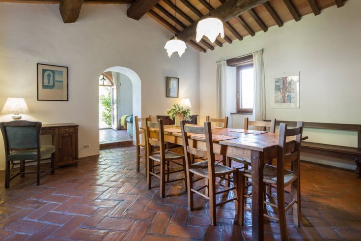 Una sala da pranzo semplice con un tavolo in legno e decorazioni in stile rustico, perfetta per pasti in compagnia.