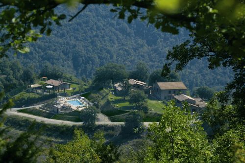 Un edificio storico circondato dalla vegetazione, che trasmette calma e serenità tra le colline umbre.
